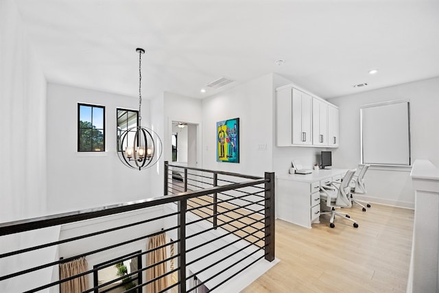 interior space featuring light wood-type flooring and an inviting chandelier