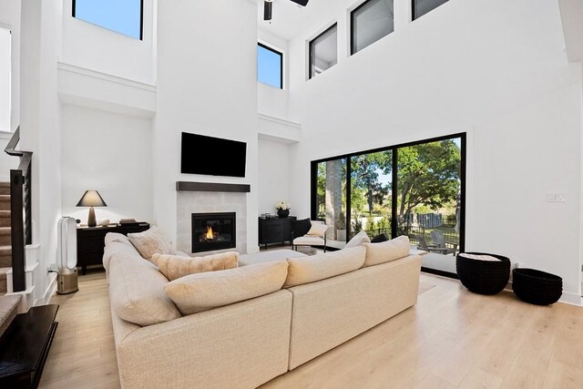 living room with a healthy amount of sunlight, a high ceiling, and light wood-type flooring