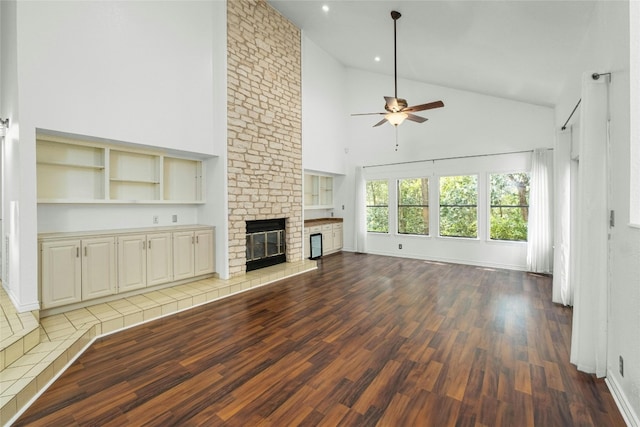 unfurnished living room with a brick fireplace, ceiling fan, high vaulted ceiling, and light hardwood / wood-style flooring