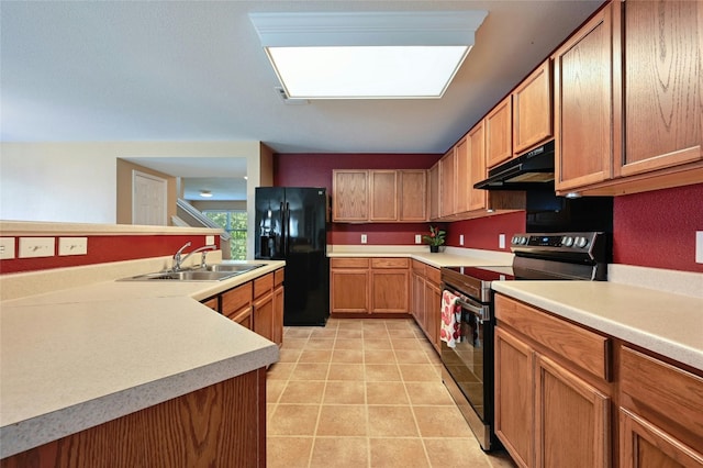 kitchen featuring electric range, black fridge, sink, a skylight, and light tile patterned floors