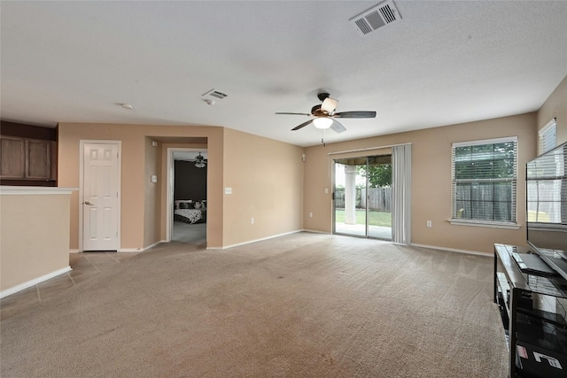 unfurnished living room with a textured ceiling, ceiling fan, and light colored carpet