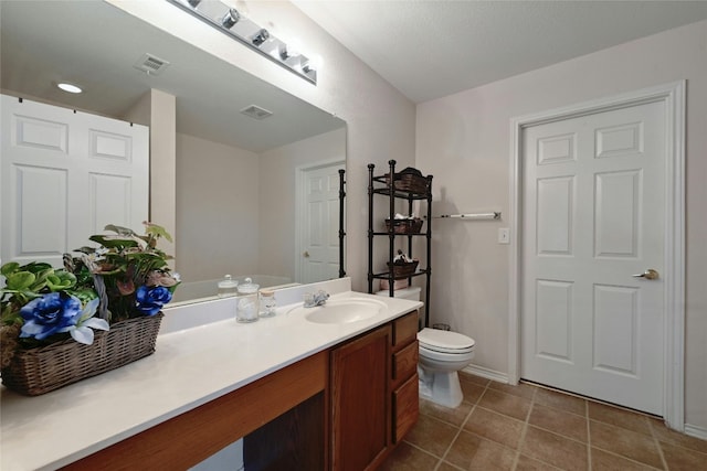 bathroom featuring tile patterned flooring, vanity, and toilet