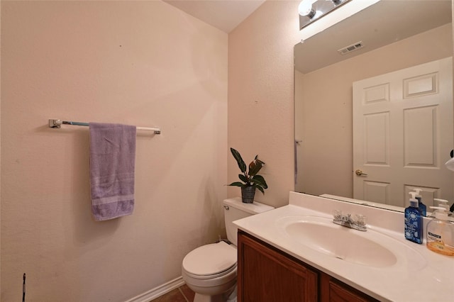 bathroom with vanity, toilet, and tile patterned floors