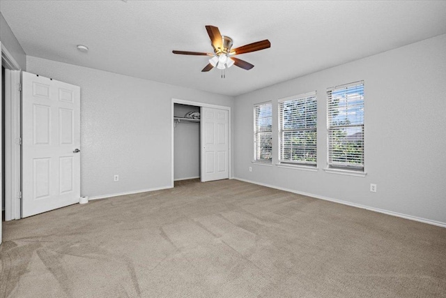 unfurnished bedroom featuring a closet, light carpet, and baseboards