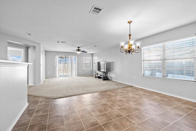 unfurnished living room featuring visible vents, carpet flooring, a textured ceiling, baseboards, and ceiling fan with notable chandelier