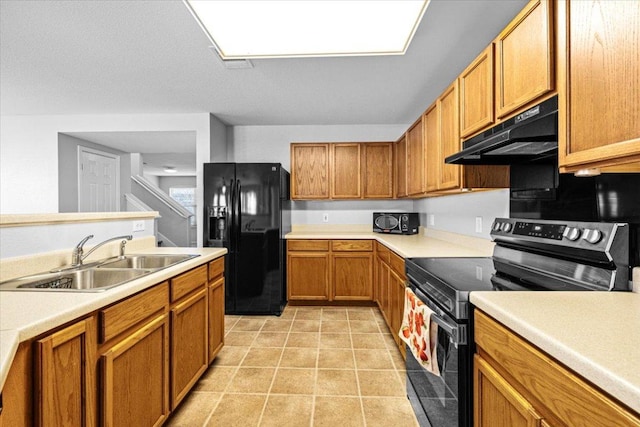 kitchen with light tile patterned flooring, under cabinet range hood, a sink, light countertops, and black appliances