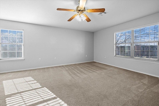 carpeted empty room featuring ceiling fan, a textured ceiling, visible vents, and baseboards