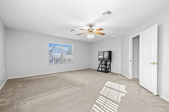 spare room featuring ceiling fan, visible vents, baseboards, and light colored carpet