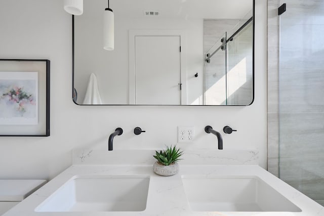 bathroom featuring vanity, toilet, and an enclosed shower