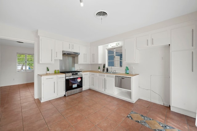 kitchen featuring white cabinetry, appliances with stainless steel finishes, light tile patterned floors, and sink