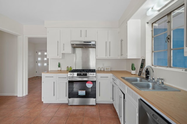 kitchen with stainless steel appliances, white cabinets, light tile patterned floors, and sink