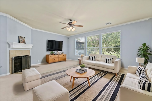 carpeted living room with ceiling fan, a fireplace, and ornamental molding