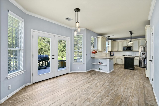 kitchen featuring french doors, decorative light fixtures, appliances with stainless steel finishes, and a wealth of natural light