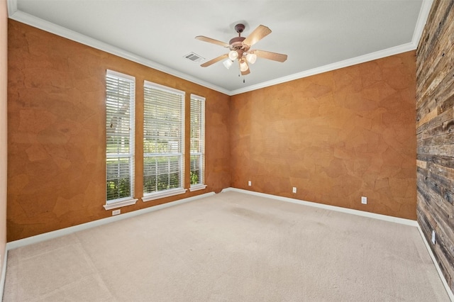 spare room with crown molding, carpet flooring, and ceiling fan