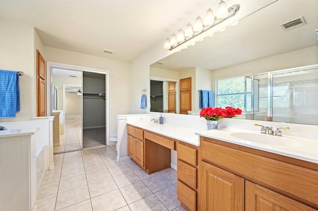 bathroom with tile patterned floors, a shower with door, vanity, and toilet