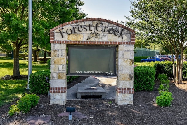 community / neighborhood sign with a yard