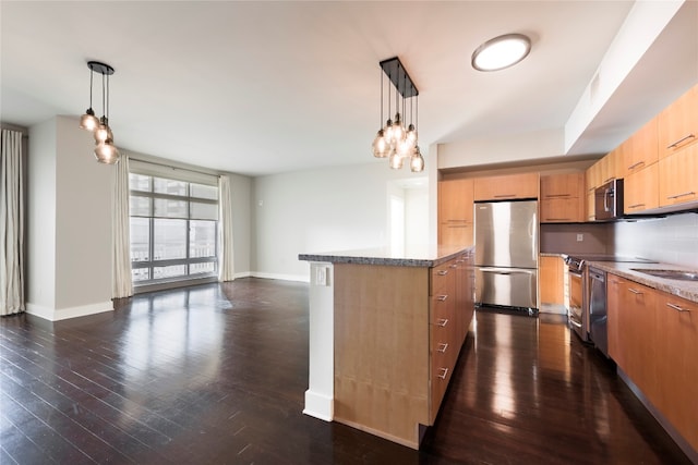 kitchen with a center island, appliances with stainless steel finishes, dark hardwood / wood-style flooring, and pendant lighting