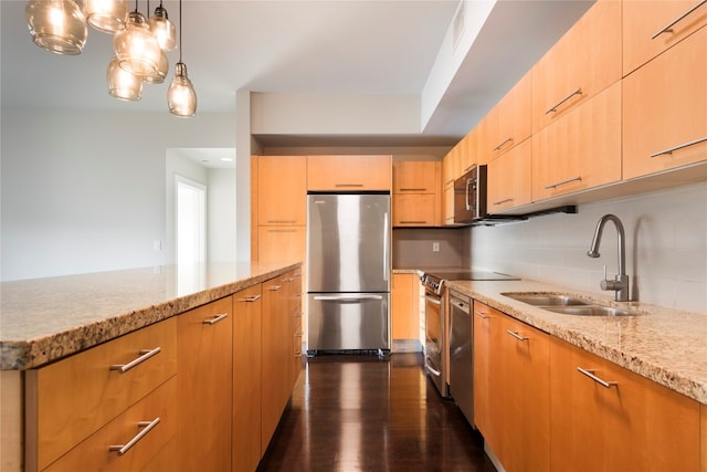 kitchen with light brown cabinets, hanging light fixtures, stainless steel appliances, sink, and dark hardwood / wood-style flooring