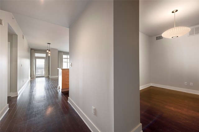 corridor with dark hardwood / wood-style flooring