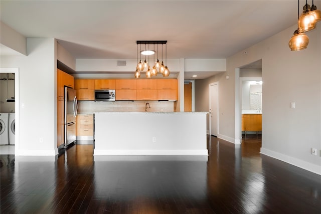 kitchen featuring tasteful backsplash, appliances with stainless steel finishes, separate washer and dryer, and hanging light fixtures