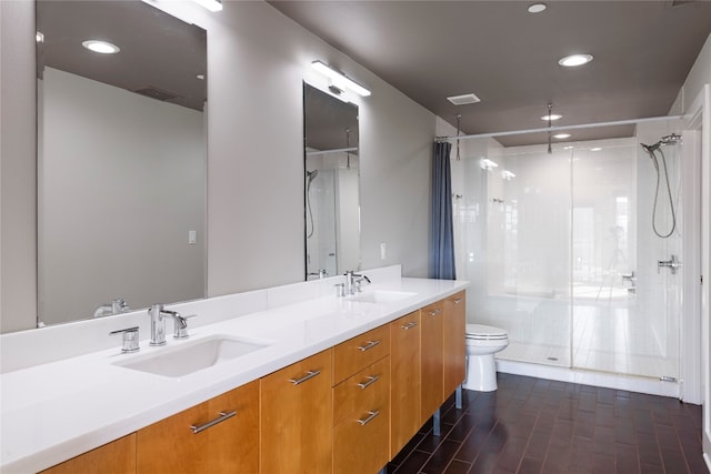 bathroom featuring vanity, toilet, and a shower with shower door