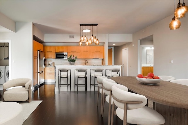 603 Davis St Unit 1202, Austin, TX 78701 - dining space with dark wood-type flooring, visible vents, and washing machine and clothes dryer