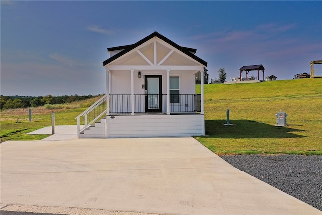 view of front of property featuring a front lawn, a gazebo, and a porch