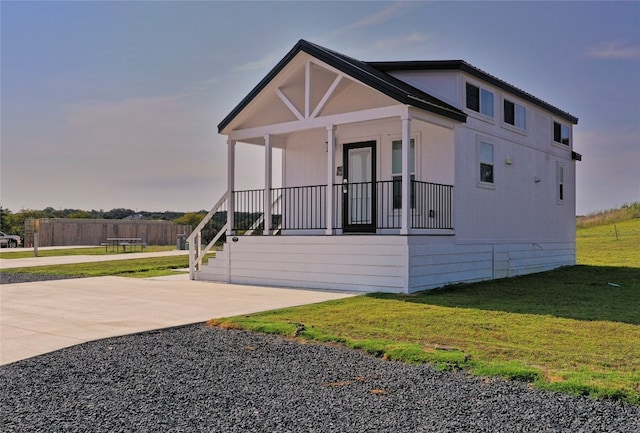 exterior space featuring covered porch and a front yard