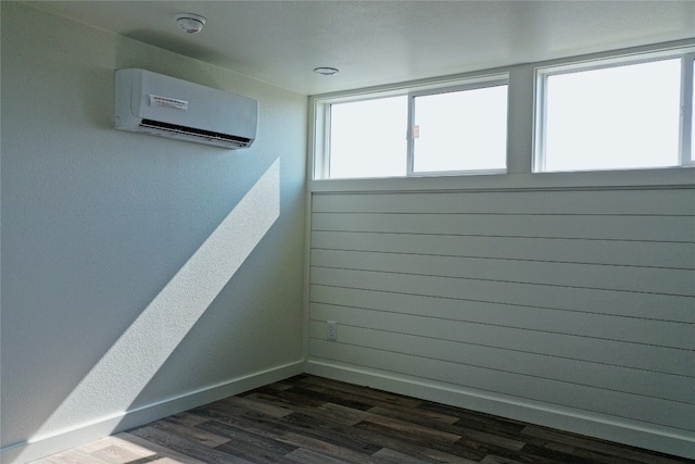 interior space with dark wood-type flooring and a wall unit AC