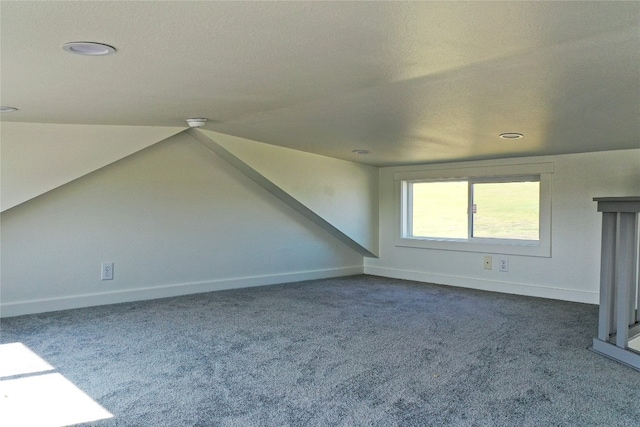 bonus room featuring a textured ceiling, carpet, and lofted ceiling