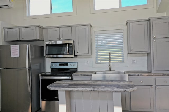 kitchen featuring gray cabinets, a wealth of natural light, appliances with stainless steel finishes, and sink