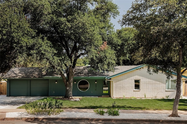 ranch-style house featuring a garage and a front lawn