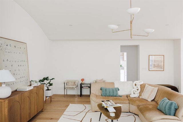 living room with light wood-type flooring and vaulted ceiling