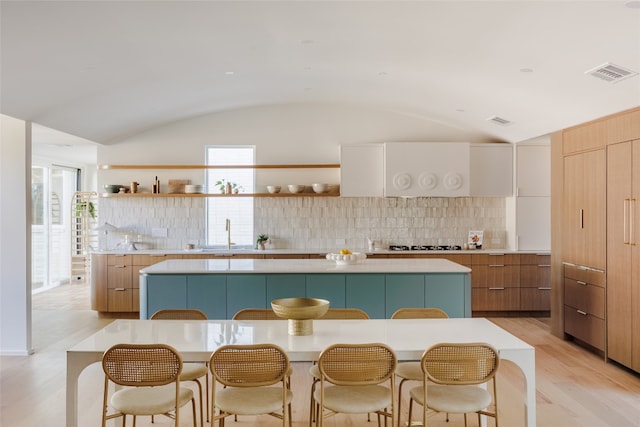 kitchen featuring a large island, lofted ceiling, and plenty of natural light