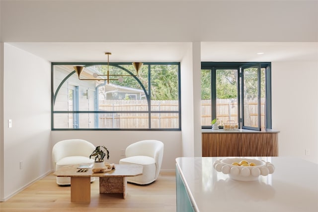 living area featuring an inviting chandelier and light hardwood / wood-style floors