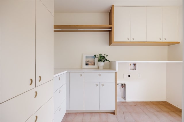 clothes washing area with washer hookup, electric dryer hookup, and cabinets