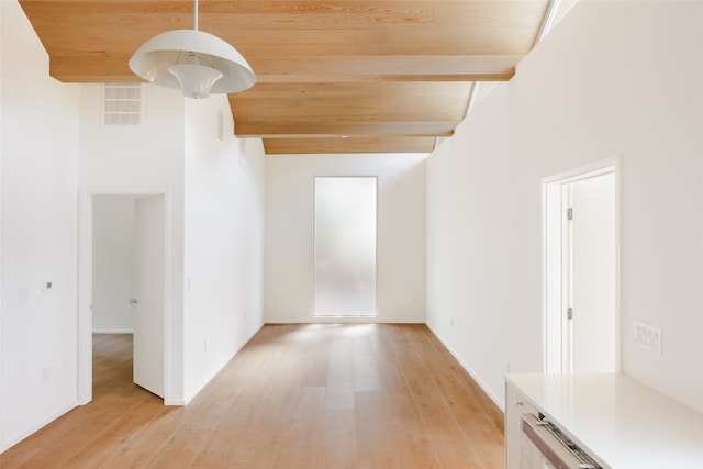 empty room featuring wood ceiling, beam ceiling, a towering ceiling, and light hardwood / wood-style flooring