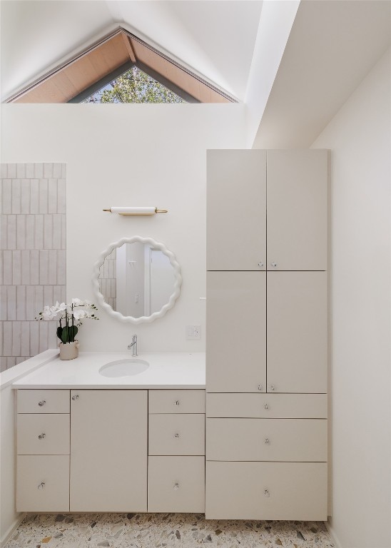 bathroom with vaulted ceiling and vanity