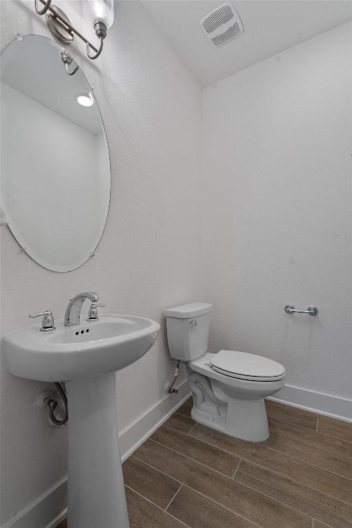 1029 Villa Rialto Vw, Leander, TX 78641 - bathroom featuring wood tiled floors, toilet, baseboards, and a sink