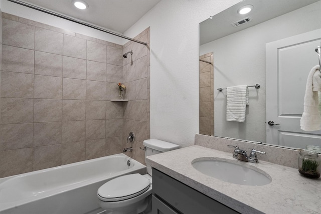 full bathroom with vanity, tiled shower / bath combo, and toilet