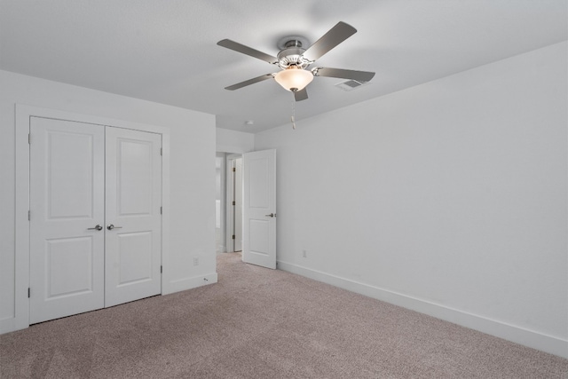 unfurnished bedroom with ceiling fan, a closet, and carpet