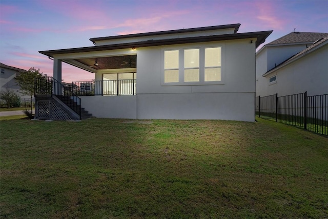 1029 Villa Rialto Vw, Leander, TX 78641 - back of house at dusk featuring ceiling fan, stairway, and stucco siding