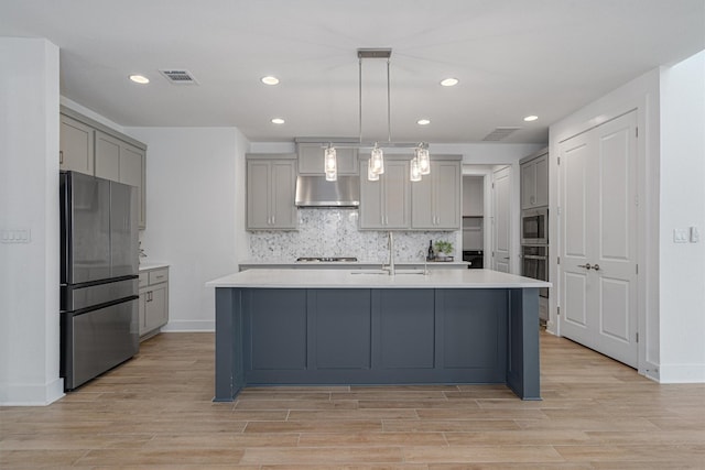 kitchen featuring sink, wall chimney exhaust hood, decorative light fixtures, gray cabinets, and appliances with stainless steel finishes