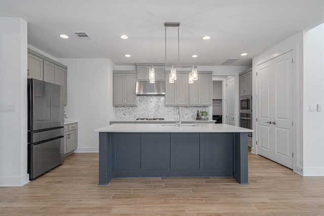 1029 Villa Rialto Vw, Leander, TX 78641 - kitchen with appliances with stainless steel finishes, gray cabinetry, a sink, light wood-type flooring, and recessed lighting