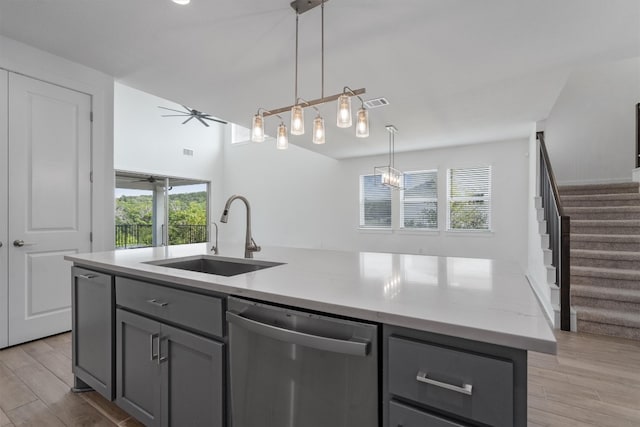 kitchen featuring ceiling fan, sink, pendant lighting, dishwasher, and an island with sink