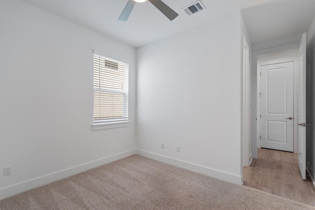 carpeted spare room featuring ceiling fan