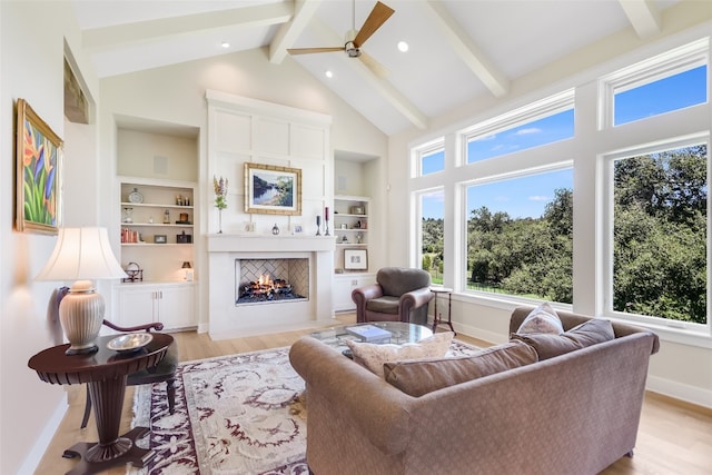 living room featuring light hardwood / wood-style floors, ceiling fan, beamed ceiling, and high vaulted ceiling