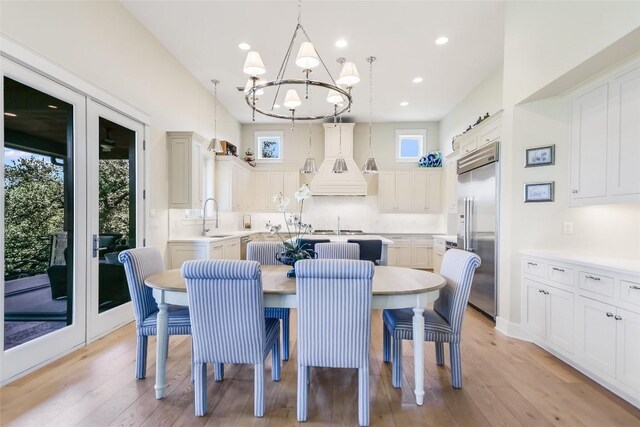 dining room featuring an inviting chandelier, sink, and light hardwood / wood-style floors