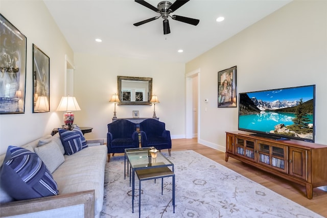 living room with ceiling fan and light hardwood / wood-style flooring