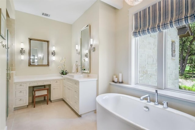 full bathroom featuring a soaking tub, vanity, visible vents, and tile patterned floors